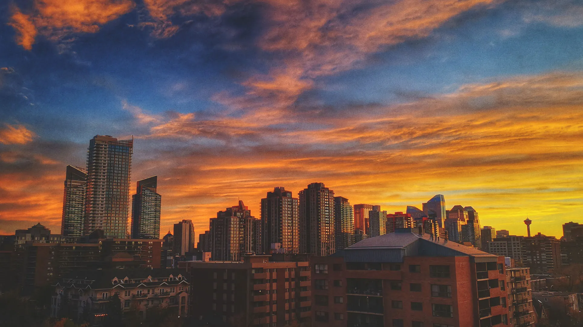downtown Calgary skyline with a vibrant orange, yellow, blue and purple sunset