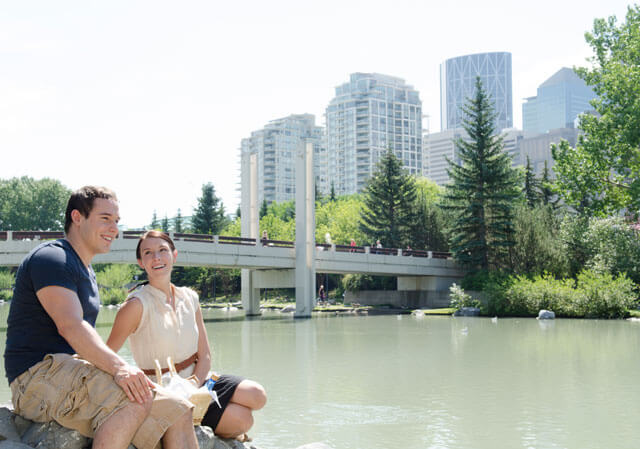 People sitting near the Bow River
