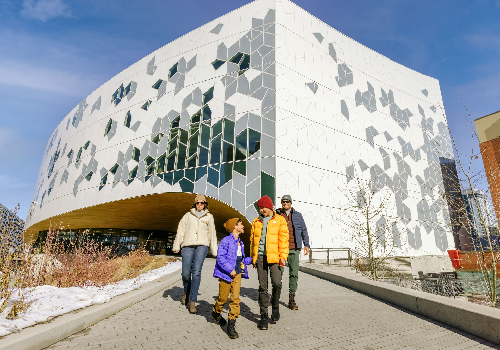 Family walking down from the Calgary Central Library in winter