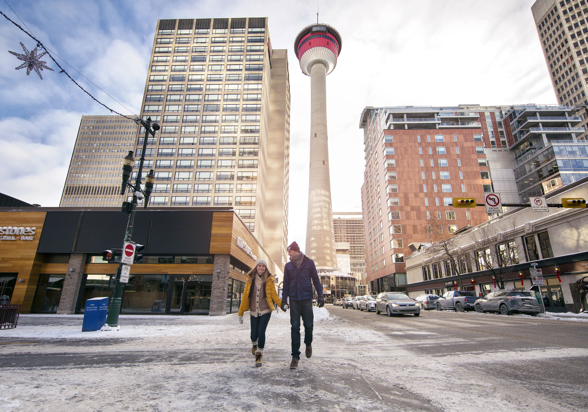 Couple walking along Stephen Ave below the Calgary Tower 