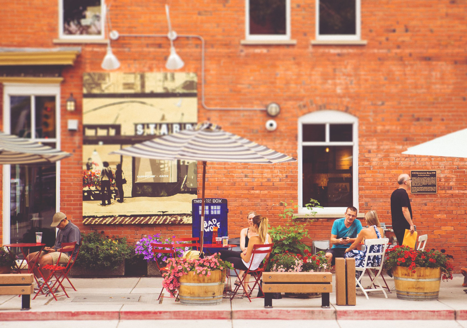 Patrons sitting on a patio in front of a brick building in Kensington