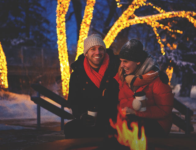 Couple sitting by an outdoor fire in winter
