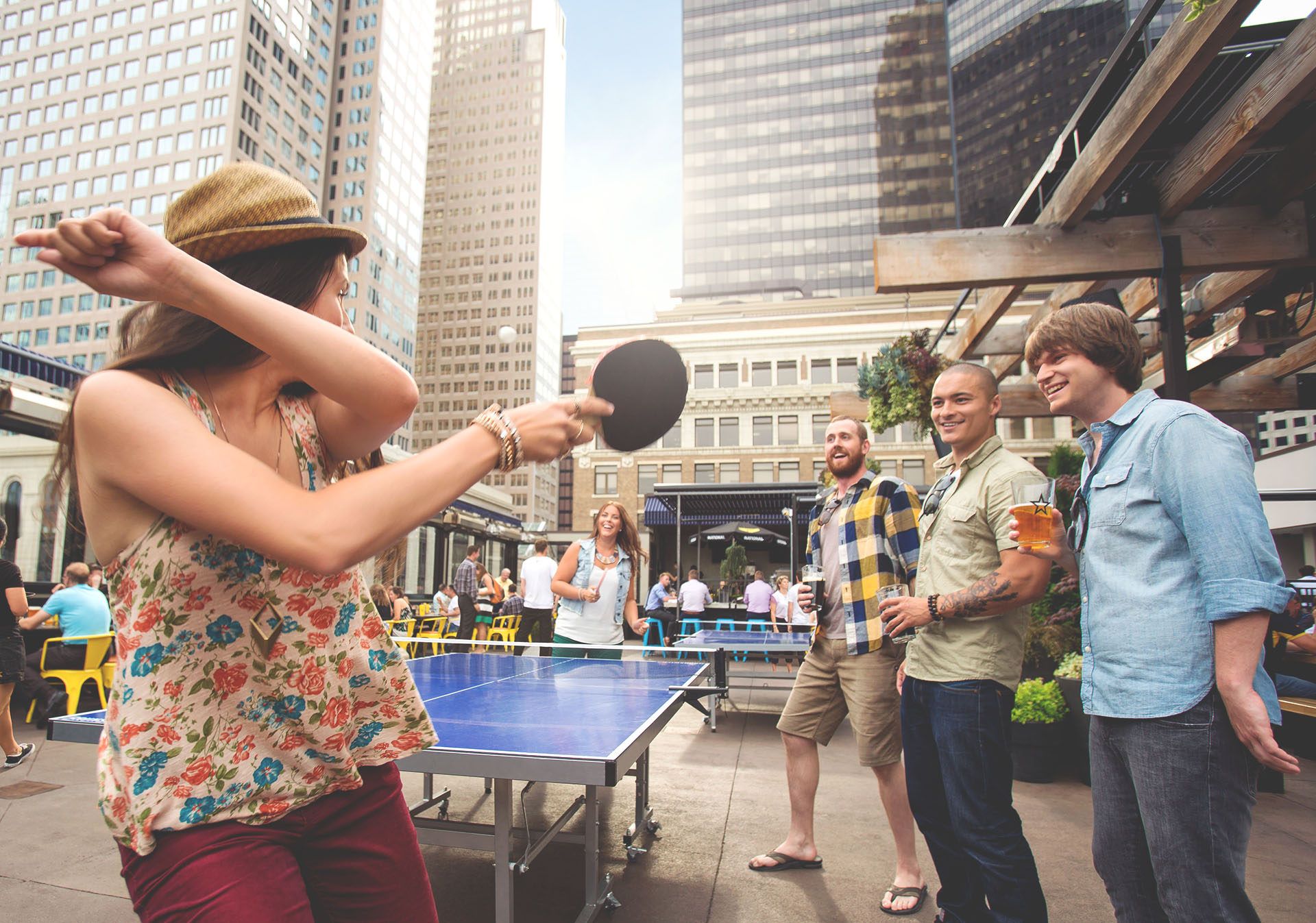 Group playing ping-pong on the rooftop patio at National on 8th