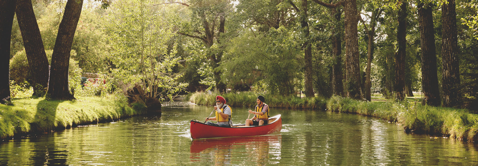 Father and son canoeing through Bowness Park