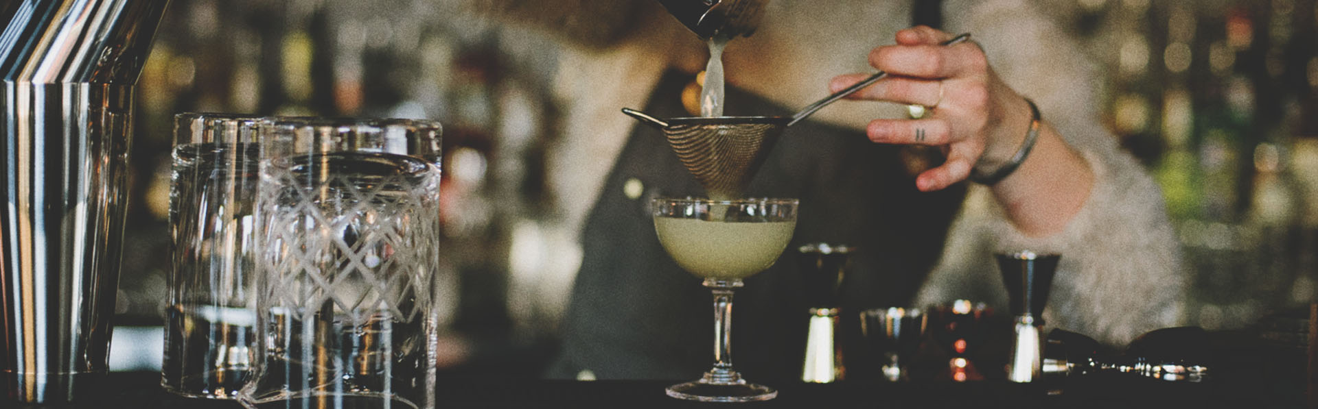 Bartender at Proof pouring a cocktail