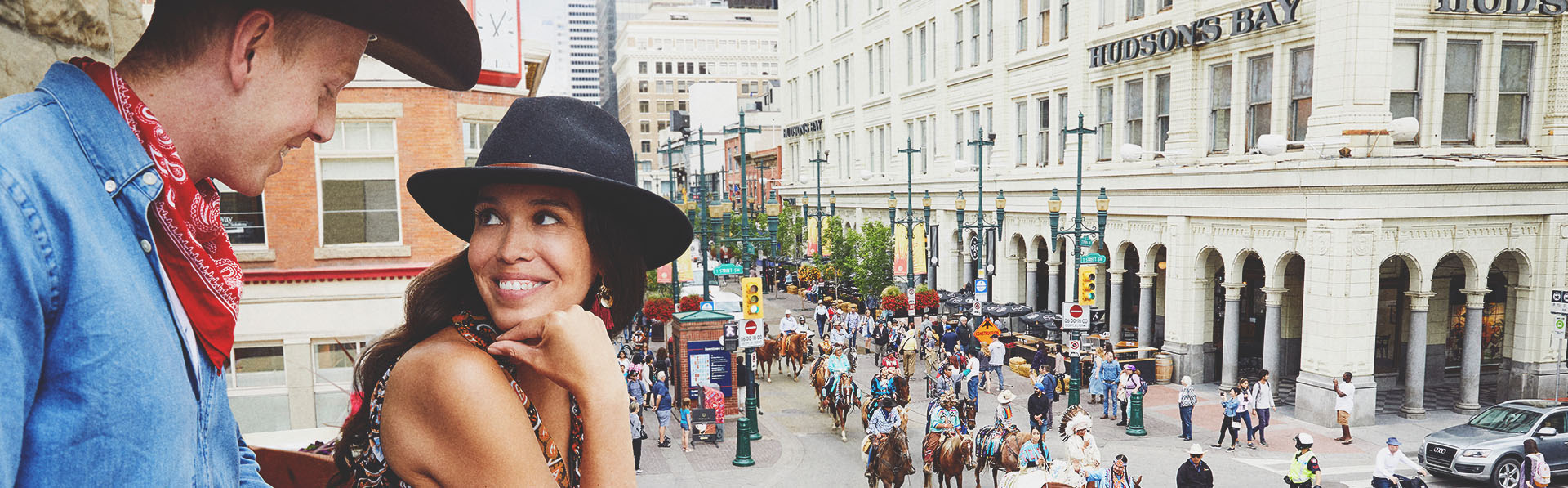 couple watching the Stampede Parade from a balcony on Stephen Ave