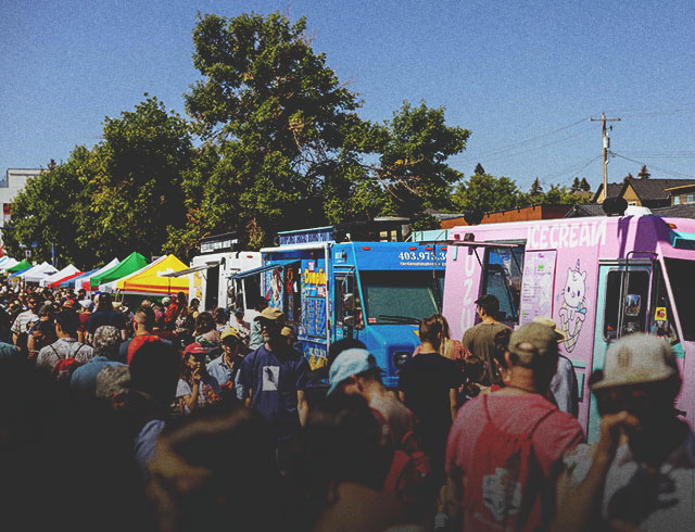 crowds of people ordering from food trucks at Marda Gras Street Festival