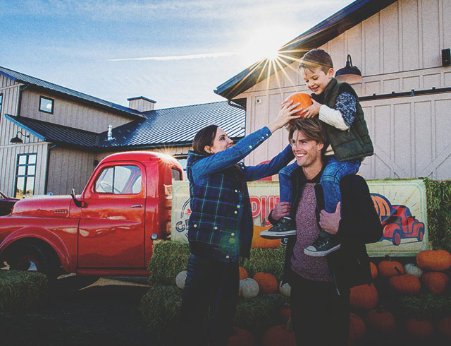 family in the pumpkin patch at Granary Road during autumn