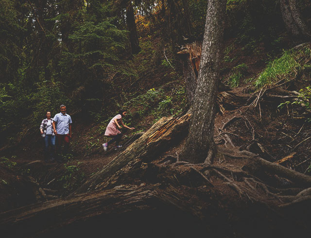 family of three walking along a dirt path with exposed tree roots on the Douglas Fir Trail
