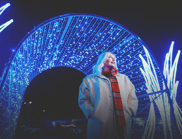 woman exploring the holiday light displays at ZOOLIGHTS