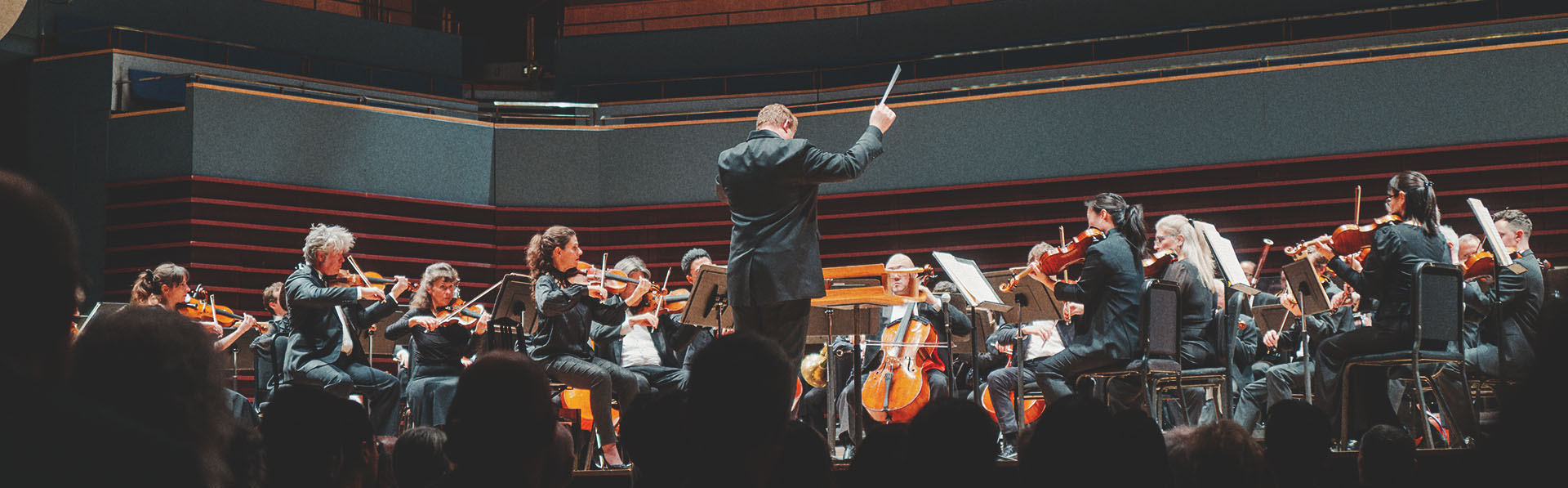 a full crowd of spectators enjoying a performance by the Calgary Philharmonic Orchestra