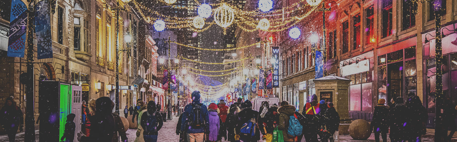 crowd exploring the Chinook Blast installations along Stephen Avenue during snowfall