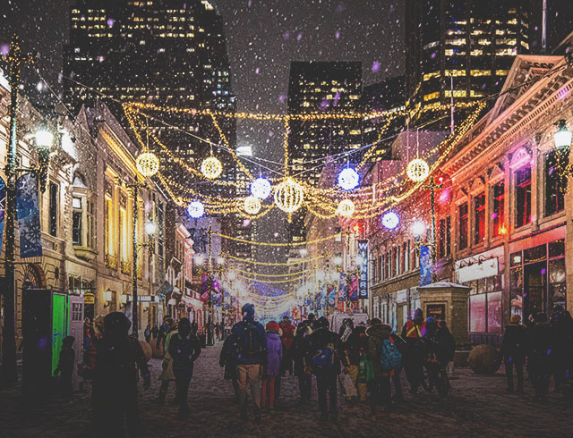 crowd exploring the Chinook Blast installations along Stephen Avenue during snowfall