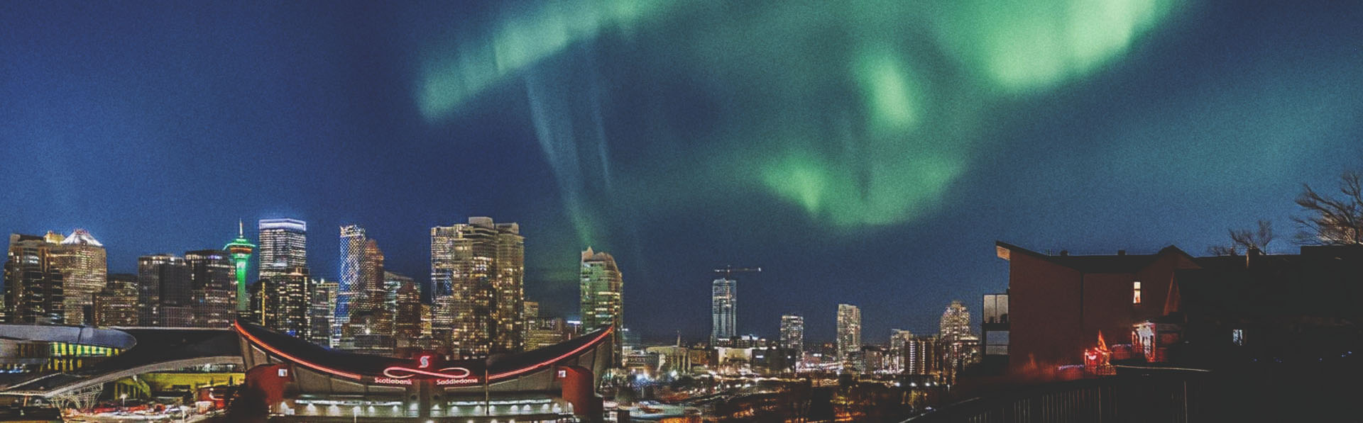 The Northern Lights shine brightly above downtown Calgary at night