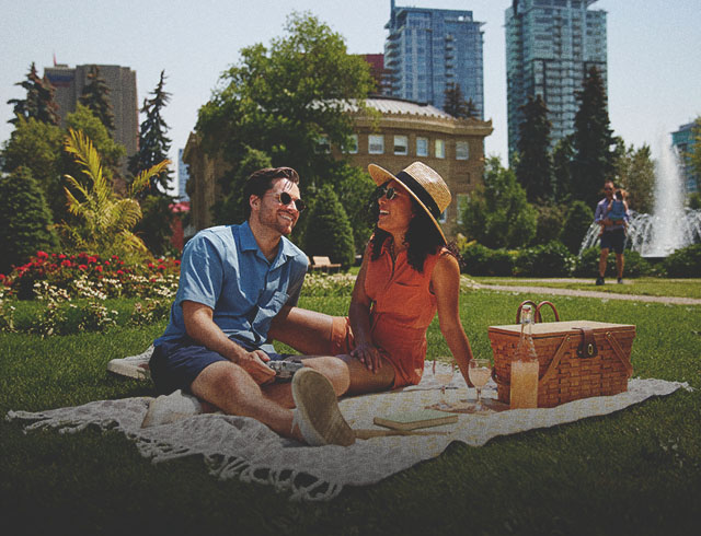 couple enjoying a picnic in the grass in a park in downtown Calgary