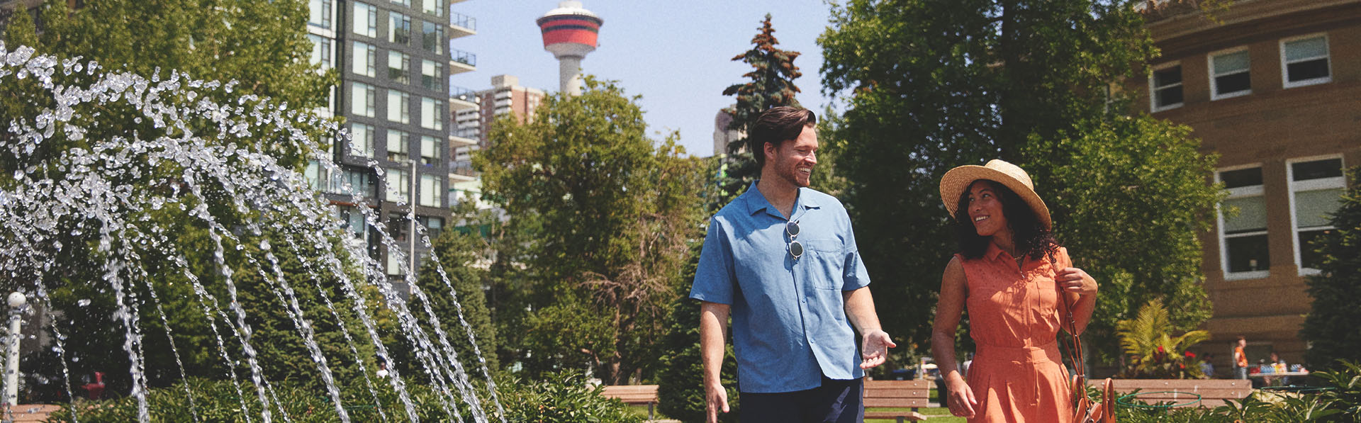 couple walking through a downtown Calgary Park on a sunny summer day