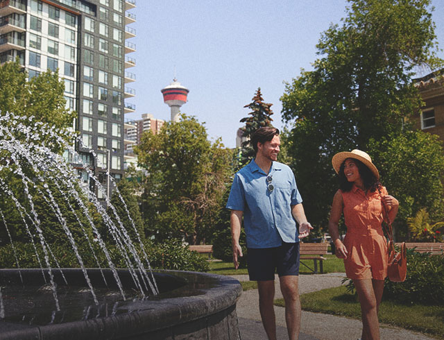 couple walking through a downtown Calgary Park on a sunny summer day