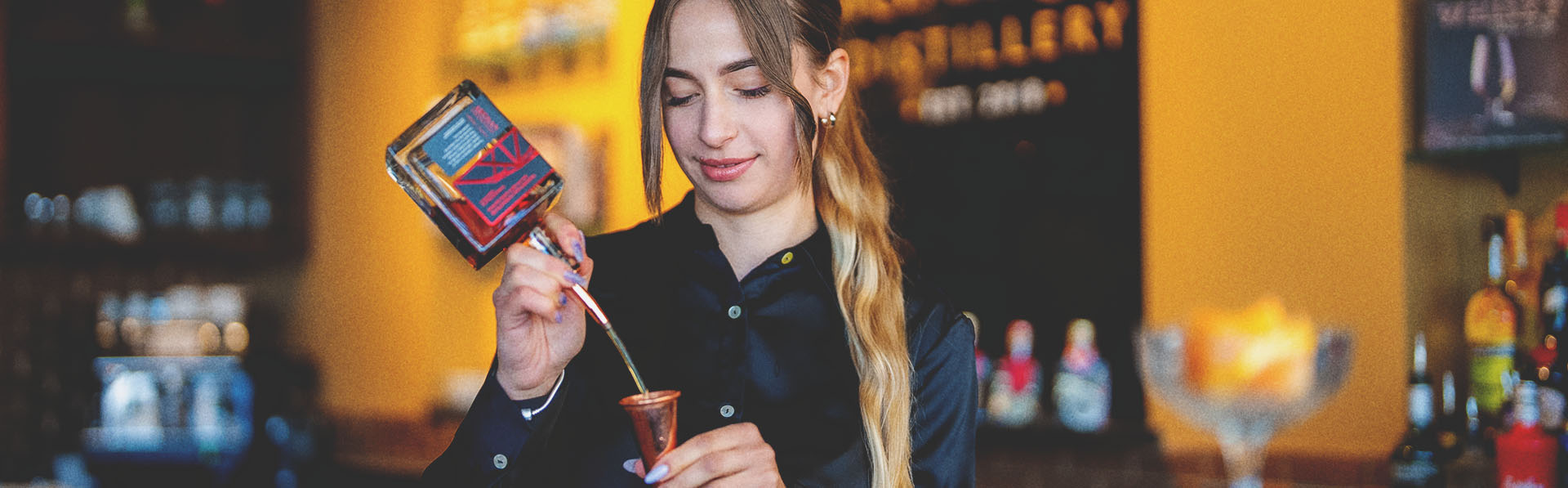 Mixologist pouring alcohol at Bridgeland Distillery