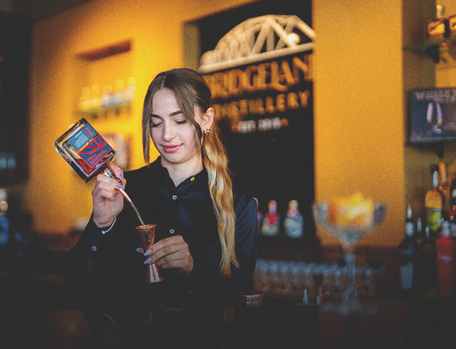 Mixologist pouring alcohol at Bridgeland Distillery