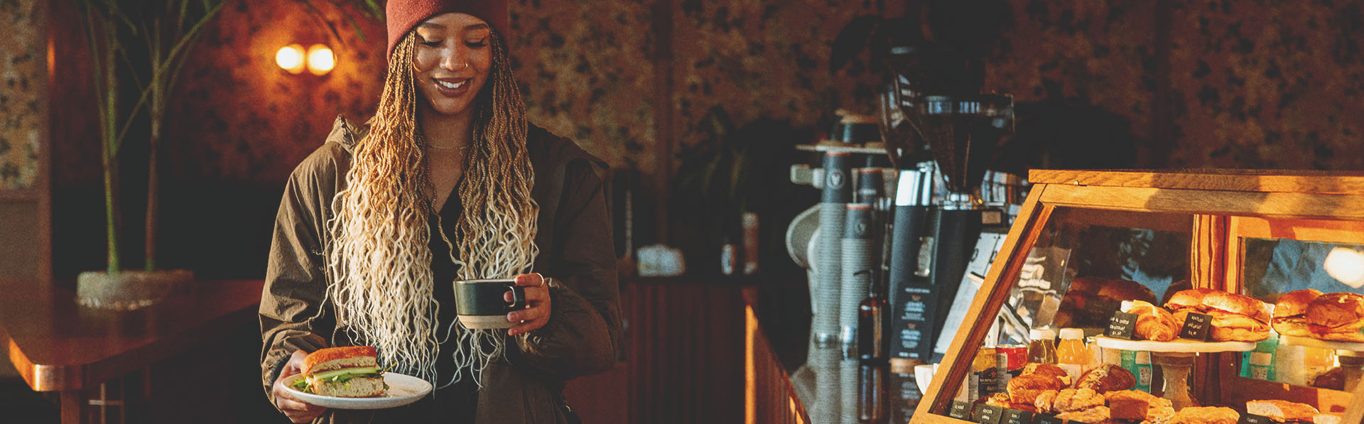 woman carrying a sandwich and latte in a local calgary coffee shop