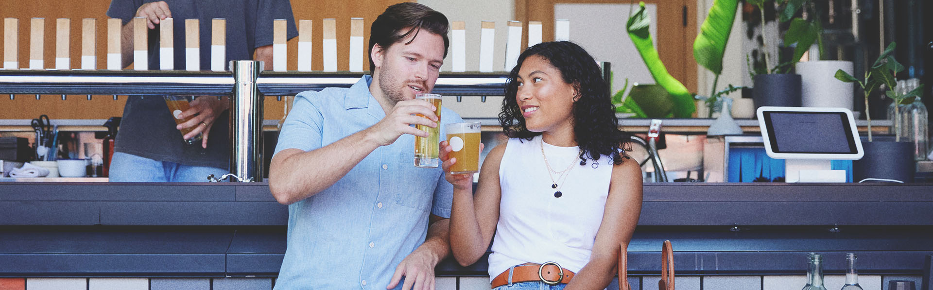 Couple enjoying pints of beer outside at 33 Acres Brewing Co in Calgary's beltline