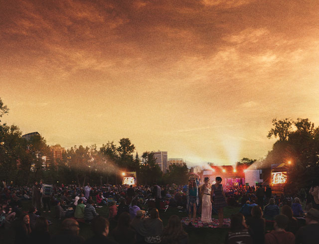 friends dancing in a crowd at Calgary Folk Music Festival outdoors during sunset