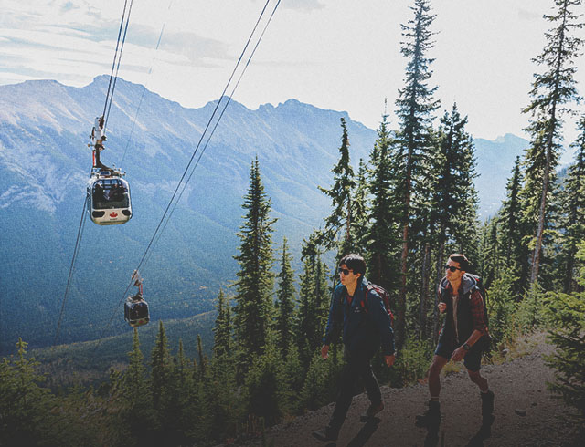 hikers hiking a trail beneath the Banff Gondola