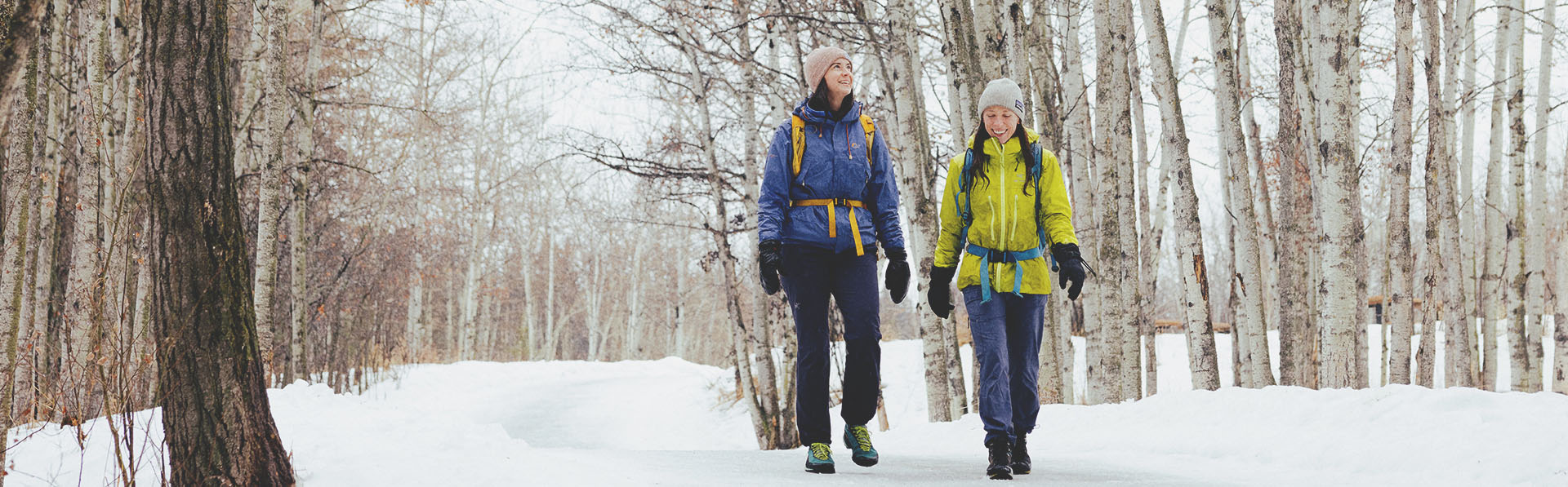 two friend hiking through Fish Creek Provincial Park in winter