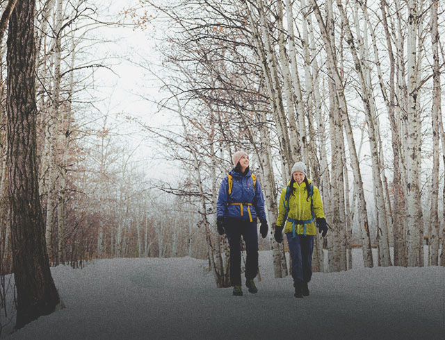two friend hiking through Fish Creek Provincial Park in winter
