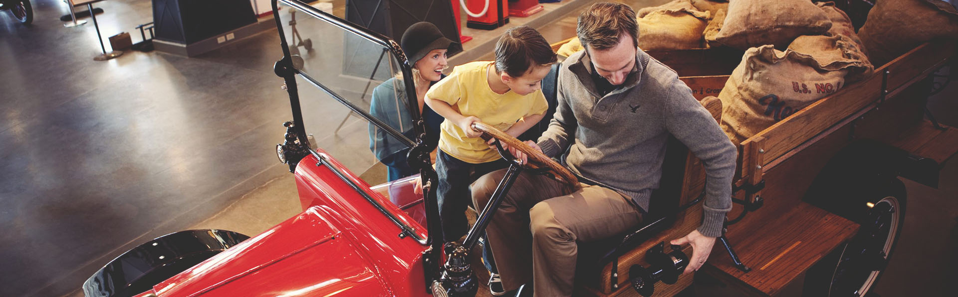 family experiencing a car at the Gasoline Alley Museum Heritage Park