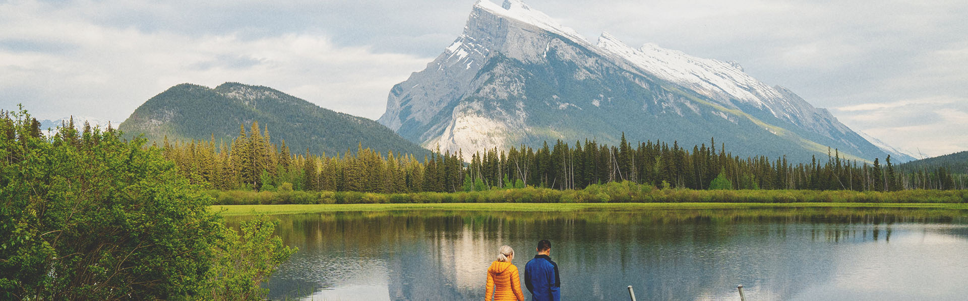 Couple walking on dock after riding bikes at Vermillion Lakes in Banff