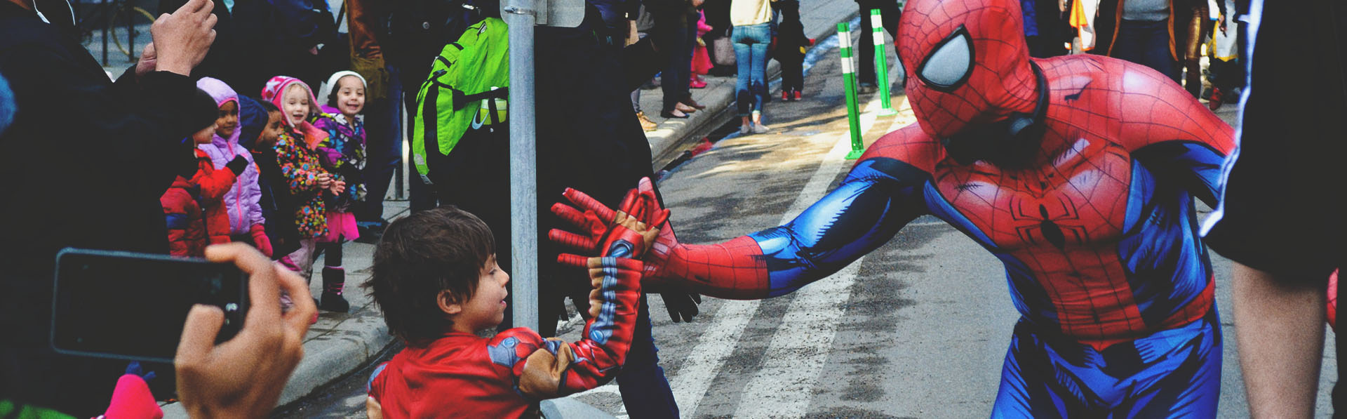 a little boy giving a spiderman a high five at the Calgary expo