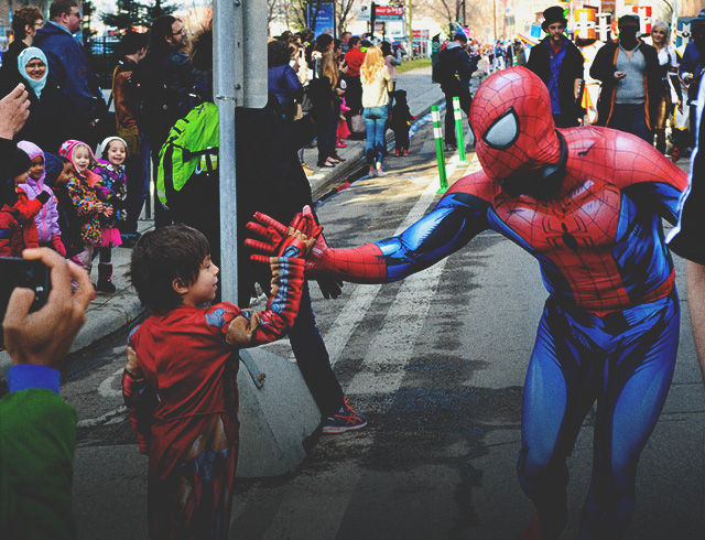 a little boy giving a spiderman a high five at the Calgary expo