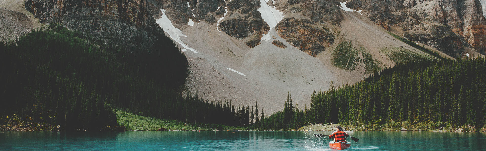 Person in a canoe on Moraine Lake surrounded by mountains in Banff National Park