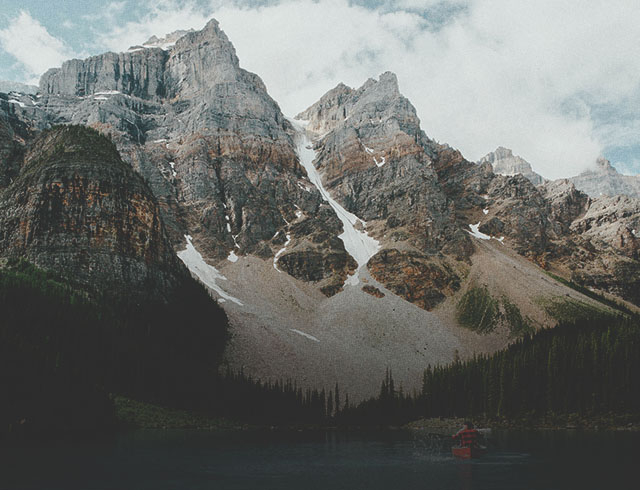 Person in a canoe on Moraine Lake surrounded by mountains in Banff National Park