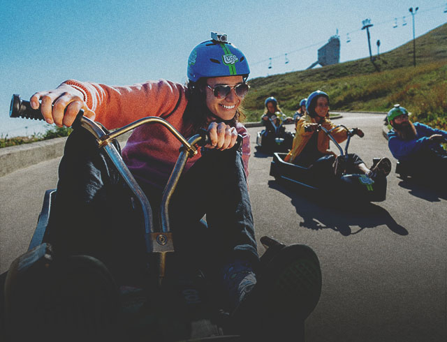 Young riders speeding down the track during a downhill karting session at WinSport