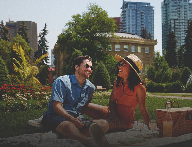 couple laughing and enjoying picnic at Central Memorial Park in Calgary