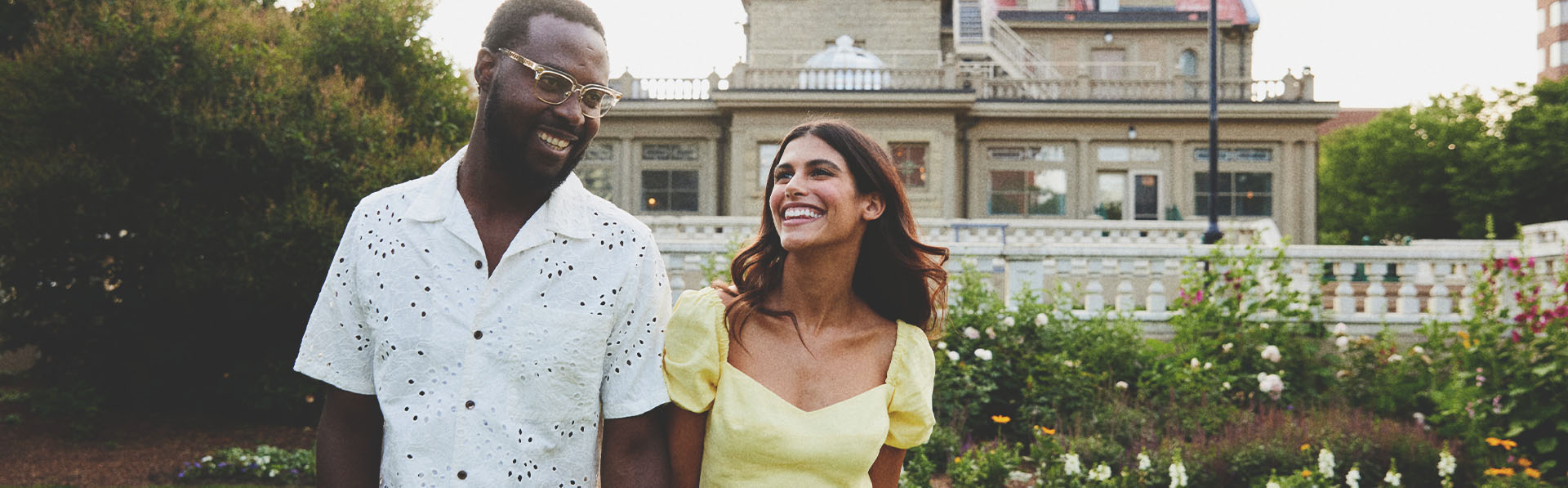 couple holding hands and smiling in front of the Lougheed House