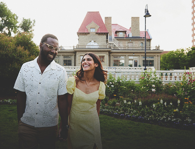 couple holding hands and smiling in front of the Lougheed House