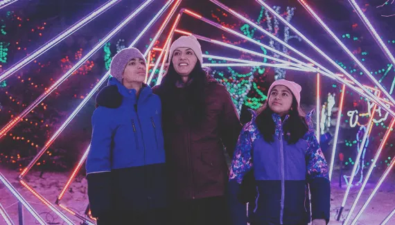 mother and two children walk through a light display at Wilder Institute/Calgary Zoo's ZOOLIGHTS