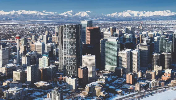 aerial of the Calgary skyline on a clear day during winter with the Rocky Mountains in the background