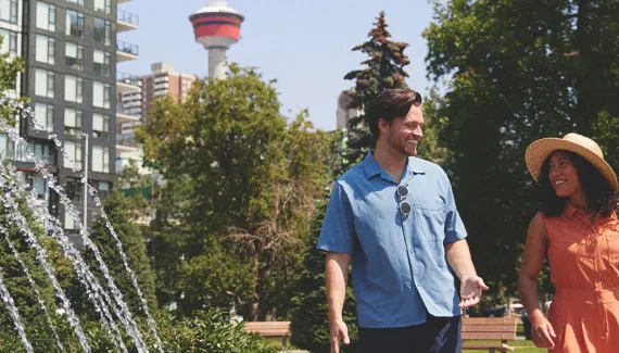 couple walking through a downtown Calgary Park on a sunny summer day