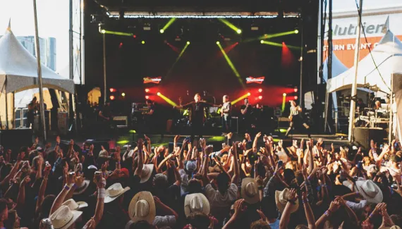 crowd cheering on a musician at the Nashville North tent on Calgary Stampede grounds