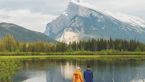 Couple walking on dock after riding bikes at Vermillion Lakes in Banff