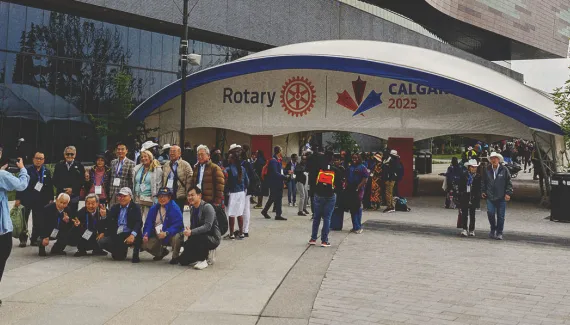Group of Rotary attendees posing for a photo in front of a large entrance gate