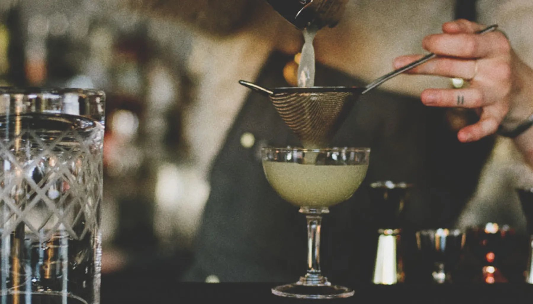 Bartender at Proof pouring a cocktail