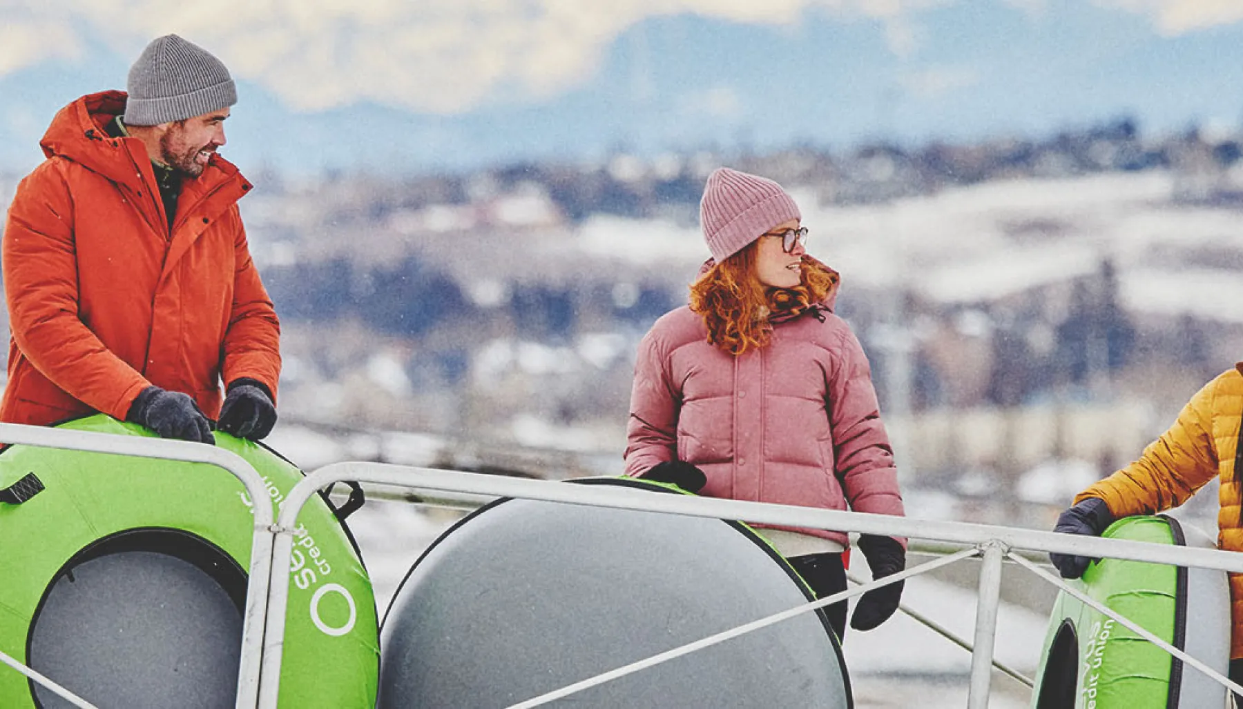 family at WinSport's Servus Tube Park with mountains in the background