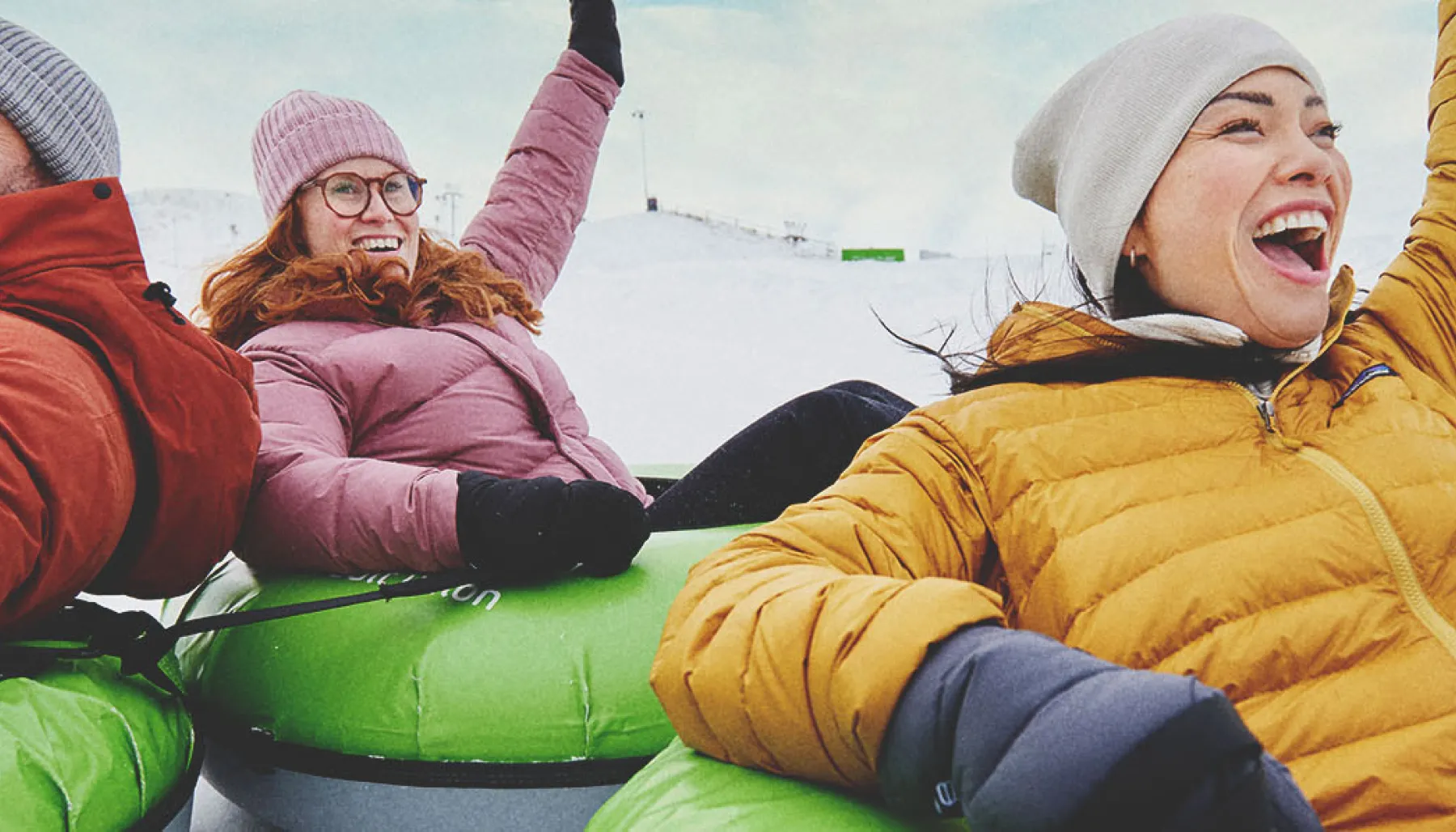 three people enjoying downhill tubing at Calgary's WinSport in winter