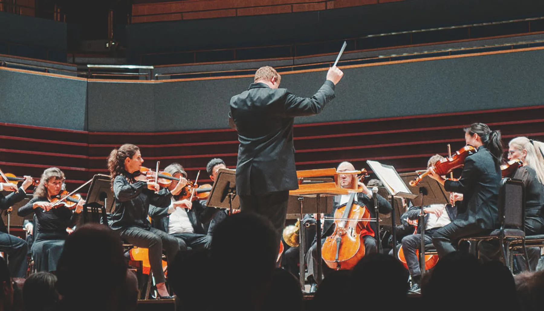 a full crowd of spectators enjoying a performance by the Calgary Philharmonic Orchestra