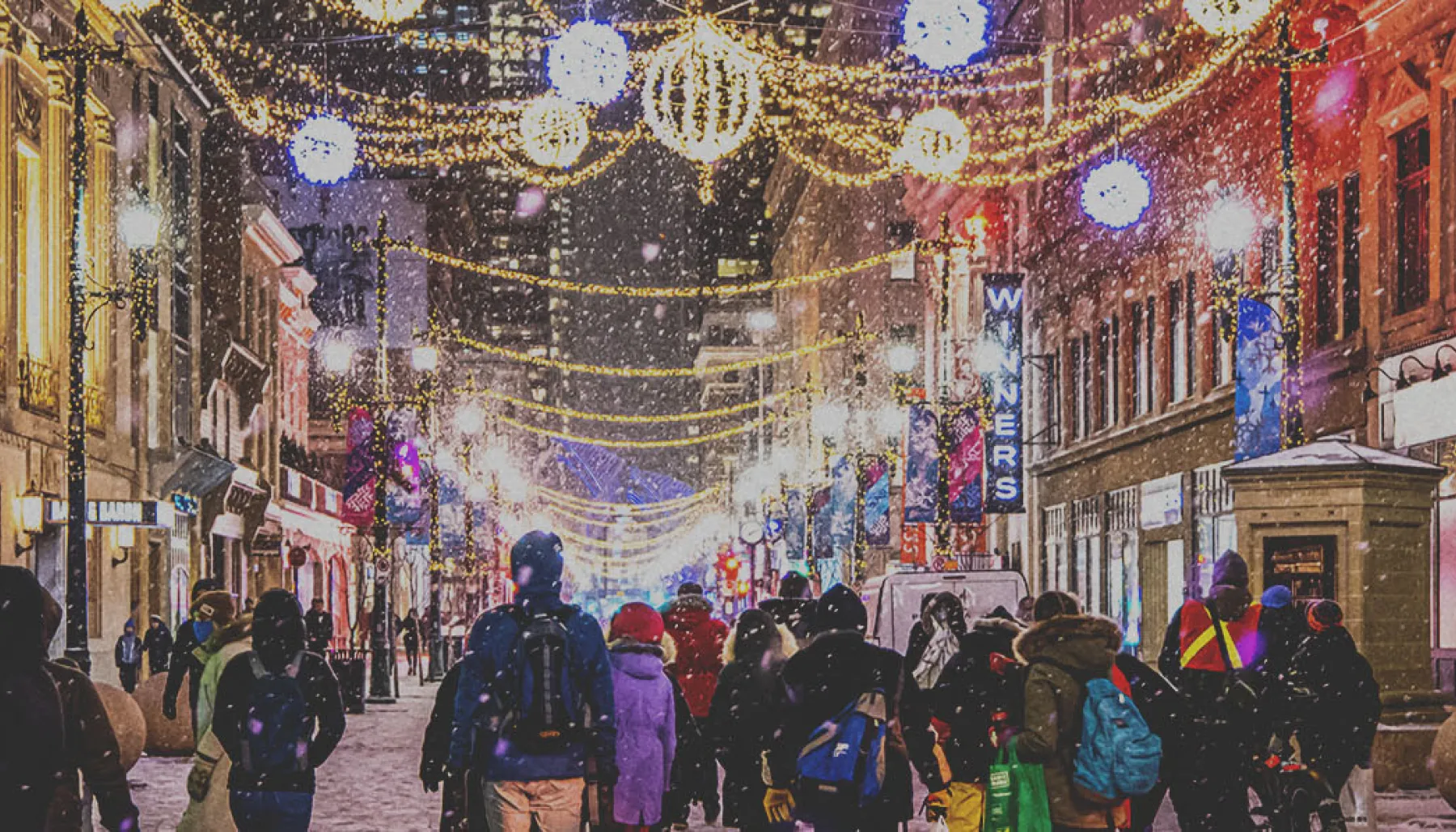 crowd exploring the Chinook Blast installations along Stephen Avenue during snowfall